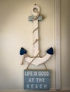 sign hanging from an anchor says Life is good at the beach Royalty Free Stock Photo