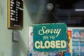 A sign hanging in a shop window saying sorry we are closed Royalty Free Stock Photo