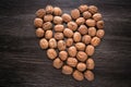 Sign Heart lined with raw walnuts on wood background. Walnut heart shape