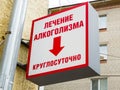 A sign on the house in the translation `Treatment of alcoholism around the clock`