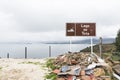 Sign identifying Lago de Tota, Lake Tota. Beneath it, a pile of rubble