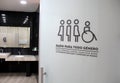 Sign of inclusive bathrooms for all genders in Spanish combating discrimination trans women and men, people with disabilities Royalty Free Stock Photo