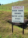 A sign indicates danger on a hill - When Horn Sounds Water Level Rises Suddenly