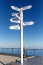 Sign indicating directions and distances to different cities of the world. The direction of the cities on the background of blue s Royalty Free Stock Photo