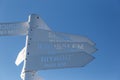 Sign indicating directions and distances to different cities of the world. The direction of the cities on the background of blue s Royalty Free Stock Photo