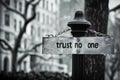 Sign with inscription 'trust no one' attached to metal post with chain, blurred background of trees and Royalty Free Stock Photo