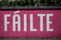 Sign in Irish language Failte welcome in English on a magenta color wall