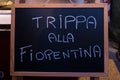 A sign with the Italian words `Florentine tripe` hung by a street food vendor
