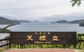 The Sign with Lettering of Amanohashidate, in engl. `Heaven Brigde, Heritage of Japan` with Miyazu Bay and Islands between a gre