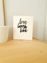 Sign, Live Laugh Love on wooden shelf, modern decoration in retro home