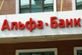 A sign with the logo of Alfa Bank over the entrance of a small branch of the bank