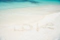 Sign love at sand beach with ocean wave crystal turquoise water. Romantic place perfect date or propose. Sand beach