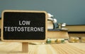 Sign low testosterone and book on wooden surface Royalty Free Stock Photo