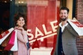 The sign that makes you part with your hard-earned cash. a young couple out on a shopping spree.