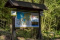 Sign with map of national park standing in the forest on sunny day