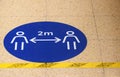 A sign / marker on a grocery supermarket shop floor showing the social distancing spacing of 2 metres Royalty Free Stock Photo