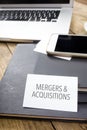 Sign Mergers & Acquisitions on Office desktop with electronic de