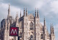 Sign metro station with blurred Milan Cathedral church on the background - italy lombardy