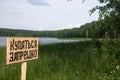 A sign near the lake with inscription swiming is prohibited, no swimming.