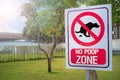 The Sign no poop zone close up image in garden day light flare.