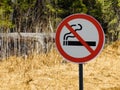 Sign no smoking on the background of forest and dry grass and trees. Royalty Free Stock Photo