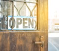 The sign is open on the old vintage doors. A tonal photograph under the antiquity. Concept. A cafe. A restaurant. Dinner.