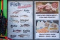 A sign outside of a shop shows the fish available - Ayer, Hilsha, Mirgal, Rohu, Katla and Boal