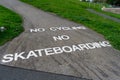 A sign painted on the ground stating no cycling and no skateboarding