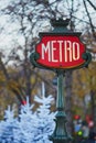 Sign of Parisian underground with Christmas trees covered with snow