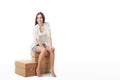 Sign people. Woman sitting on blank cardboard boxes. Casual young beautiful blonde model isolated on white background. Royalty Free Stock Photo