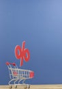 Sign percentages falling into shopping cart on dark blue background