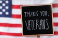 Sign with phrase Thank You, Veterans against American flag, closeup. Memorial Day Royalty Free Stock Photo