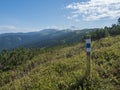 sign pole with tourist mark at ridge of Low Tatras mountains, hiking trail with mountain meadow, scrub pine and grassy Royalty Free Stock Photo