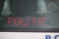 Sign in a police car behind back screen with text politie