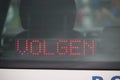 Sign in a police car behind back screen with text volgen