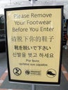 A sign posted on the door of a mosque calls in different languages for us to take off our shoes