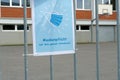 A sign poster on school yard in German language saying: a face mask is obligatory on the whole school ground.