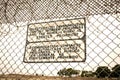 Sign at a prison fence with barbed wire limiting contact with inmates in both english and spanish