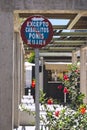 Sign of Prohibited to park ponies and Horses, next to a rosebush of flowers Royalty Free Stock Photo