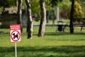 Sign prohibiting dog walking in a park, dont walk with dog on green lawn in park. Dog walking prohibited. Inscription on sign on Royalty Free Stock Photo