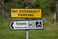 Sign on a public parking bay with the English text No overnight Parking, Toilets, Admission 20p, WC