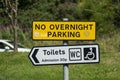 Sign on a public parking bay with the English text No overnight Parking, Toilets, Admission 20p, WC Royalty Free Stock Photo