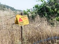 A sign reading `Danger Mines!` hangs from a barbed wire fence in the Golan Heights, near the border with Syria, Israel Royalty Free Stock Photo