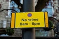 A sign reading `no crime 8am-6pm`