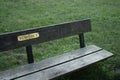 A sign reading `reminisce` on a park bench