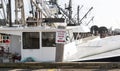 Sign reads fisherman parking only at a commercial dock with fishing vessals Royalty Free Stock Photo