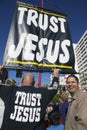 Sign reads Trust Jesus sign and man mocking him, Chinese New Year, Los Angeles, California, USA