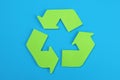 Sign of recycling made of green paper on a blue background, the concept of protection, preservation of the environment