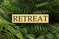 Sign Retreat on green fern plant with lush leaves, closeup Royalty Free Stock Photo