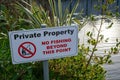 A sign on a river bank reading private property no fishing beyond this point Royalty Free Stock Photo